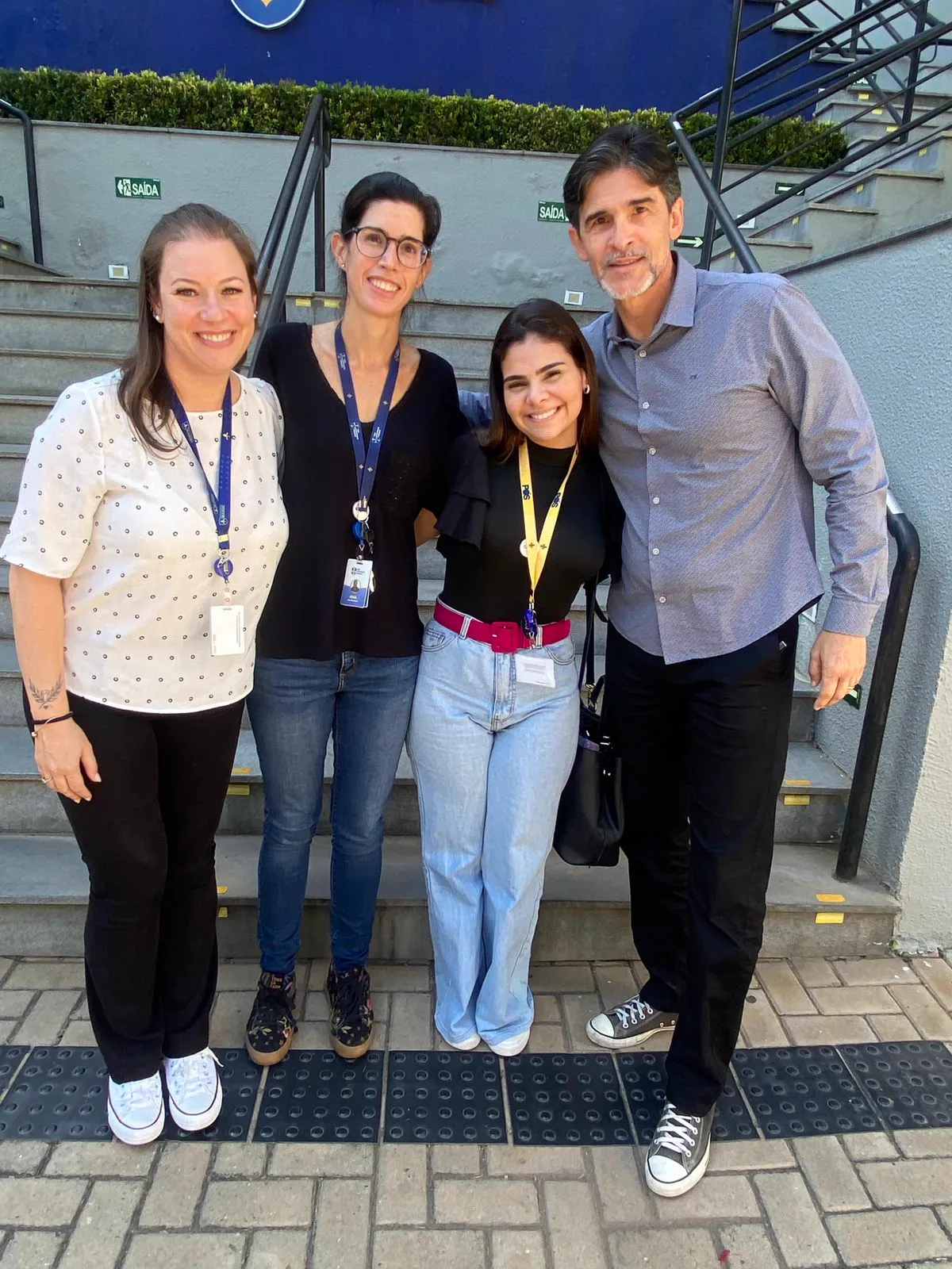 A Dra. Desirée com professores e uma colega em frente à faculdade.